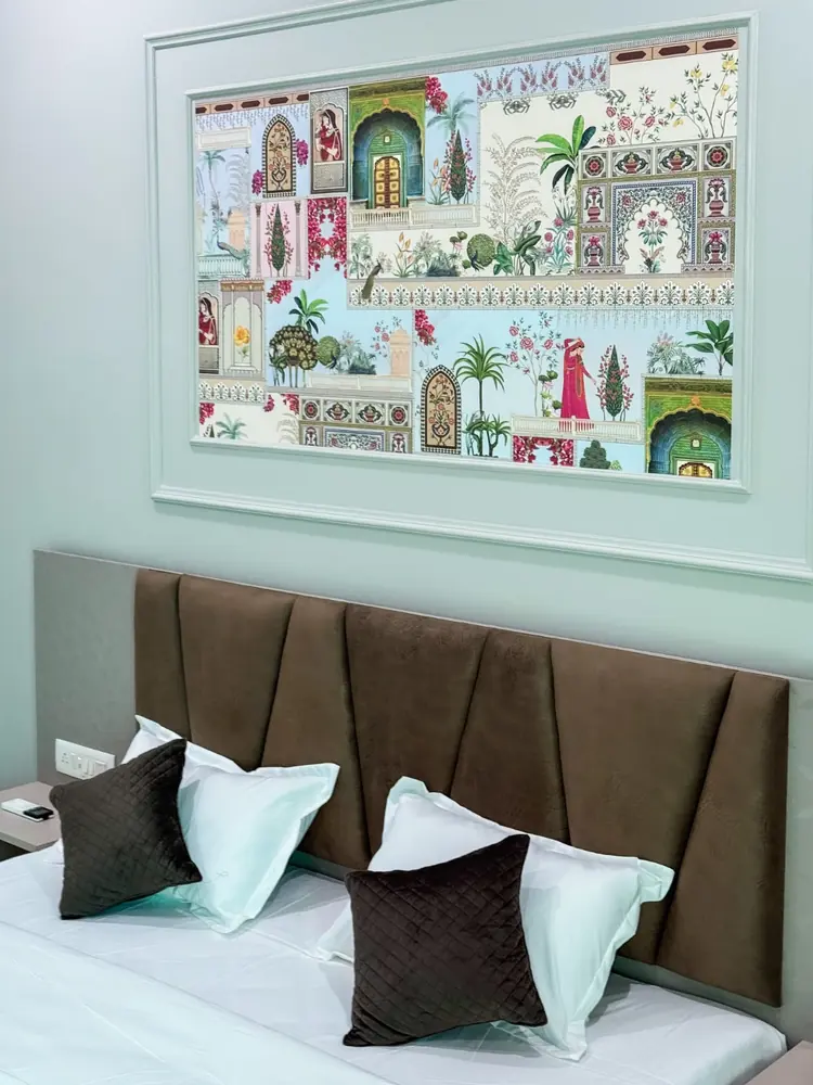 Freshly made bed with brown cushions and Rajasthani art