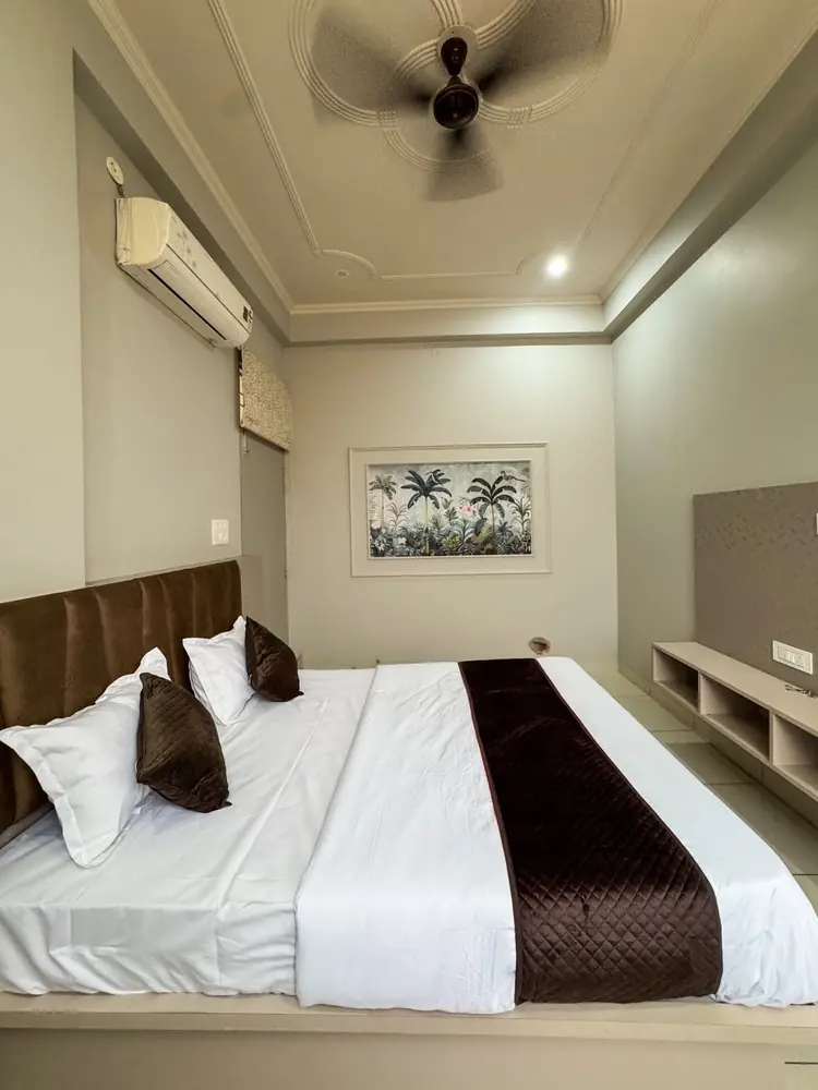 Queen bed with ceiling fan and framed art