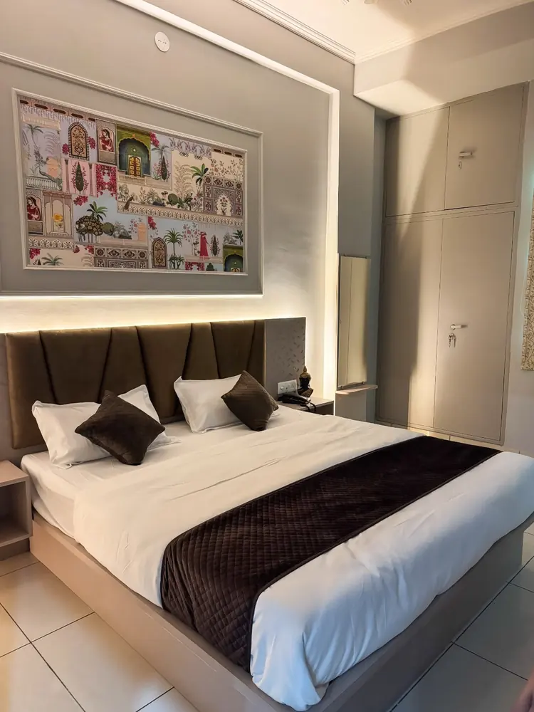 Spacious bedroom with queen bed and colourful Rajasthani mural